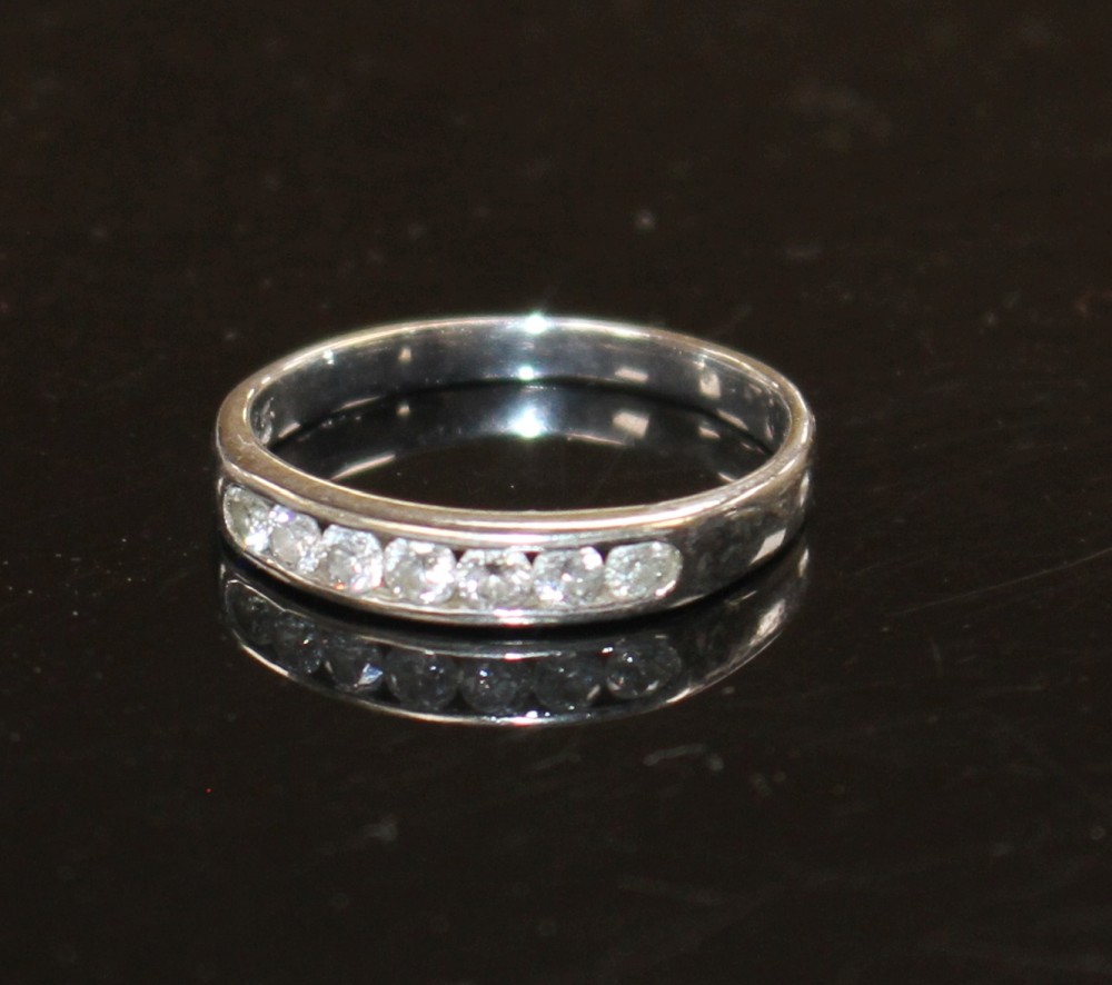 A modern 18ct white gold and seven stone diamond set half eternity ring, size L, gross weight 2.2 grams.